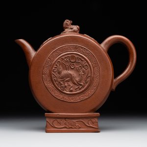 A Chinese circle-shaped Yixing stoneware 'kylin' teapot with relief design, Kangxi — photo 1