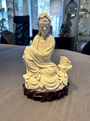 A Chinese Dehua blanc de Chine figure of a seated Guanyin on wooden stand, 19/20th C. — photo 1
