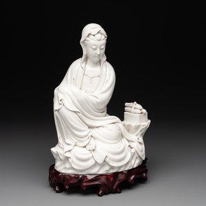 A Chinese Dehua blanc de Chine figure of a seated Guanyin on wooden stand, 19/20th C. — photo 1