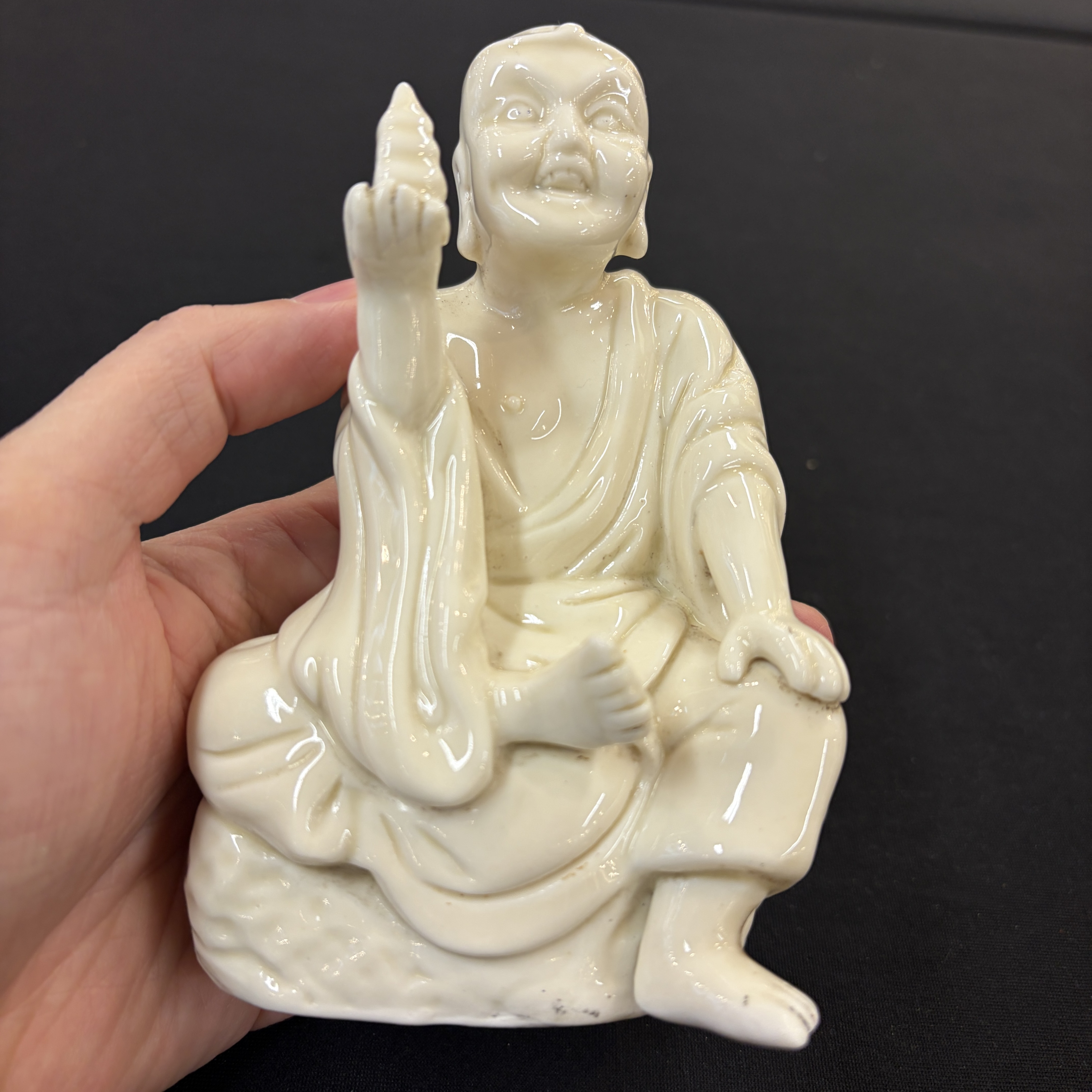 A Chinese Dehua blanc de Chine figure of Luohan and three monochrome wares, one with a wooden stand — photo 1