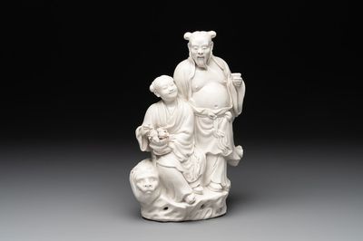 A Chinese Dehua blanc de Chine group of a man and a seated boy on a lion, 20th C.