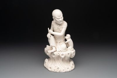 A Chinese Dehua blanc de Chine group of a seated Luohan with a monkey, 20th C.