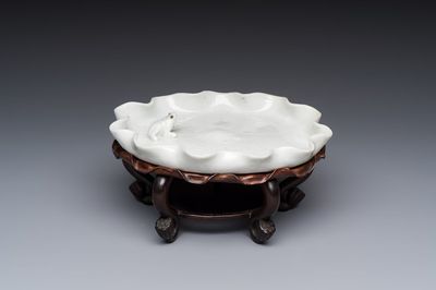 A Chinese Dehua blanc de Chine 'Lotus Leaf and Frog' brush washer on a wooden stand, Kangxi/Yongzheng
