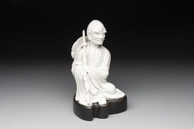 A Chinese Dehua blanc de Chine Luohan on wooden stand, 19/20th C.