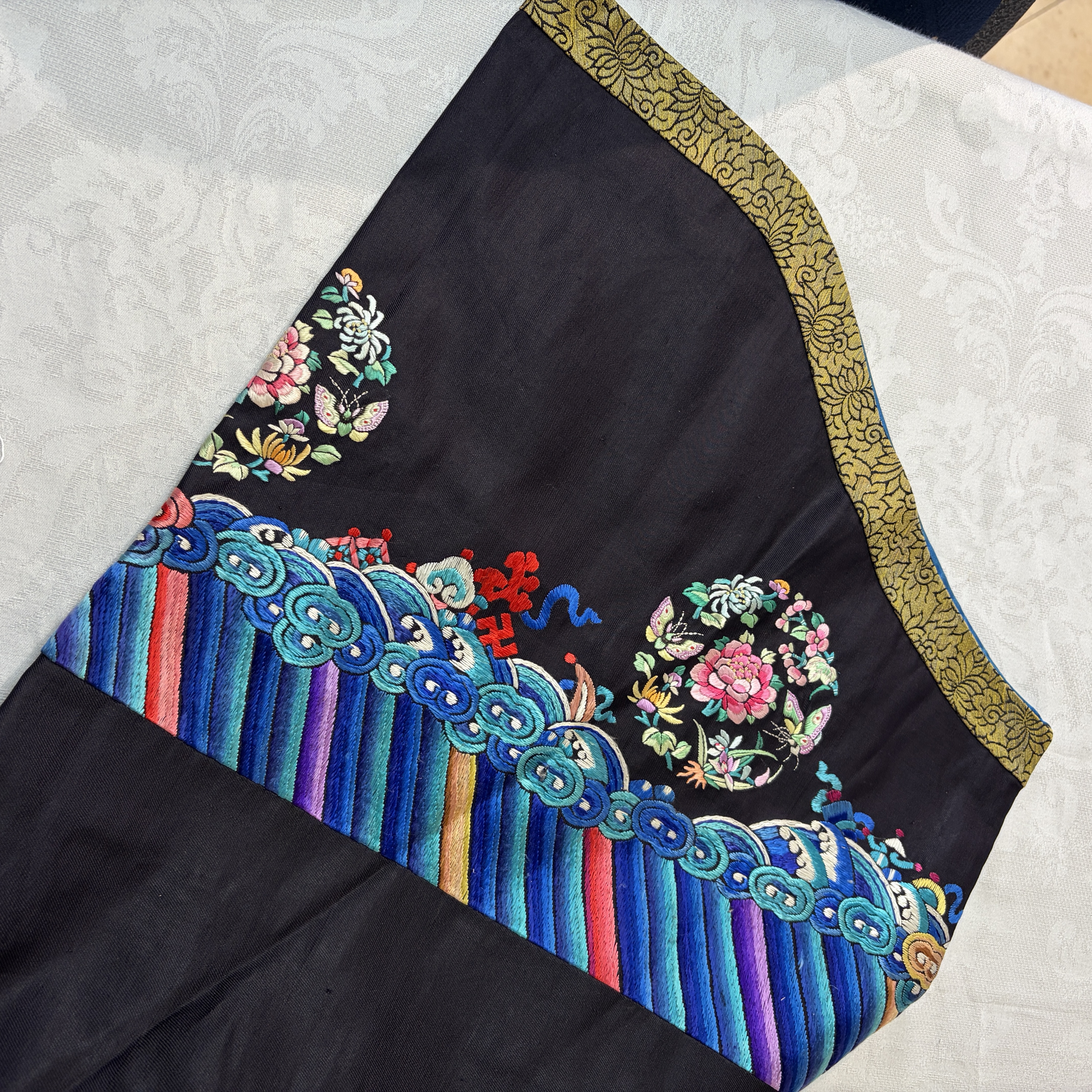 A Chinese embroidered silk dark-blue-ground robe with floral medallions — photo 17