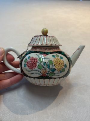 A Chinese famille rose black-ground teapot and stand with floral design, Yongzheng/Qianlong — photo 1