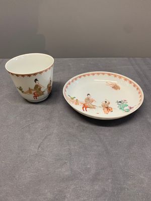 A Chinese famille rose cup and saucer with a lady playing flute, a boy and a phoenix, Qianlong — photo 1