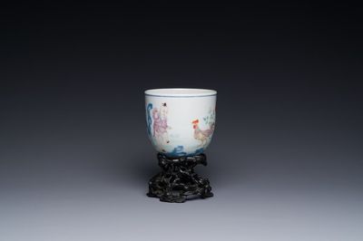 A Chinese famille rose cup with a boy and a rooster on wooden base, Qianlong mark, 20th C.