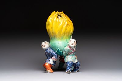 A Chinese famille rose figure of three boys holding a Buddha’s hand, Republic
