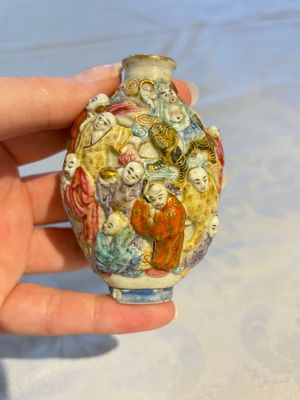 A Chinese famille rose moulded '18 Luohan' snuff bottle, Qianlong mark, 19th C. — photo 1