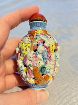 A Chinese famille rose moulded, reticulated and double-walled '18 Luohan' snuff bottle, Qianlong mark, 19th C. — photo 1