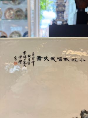 A Chinese famille rose plaque with a sage and a lady in a garden, signed Huang Can 黃燦, Republic — foto 6