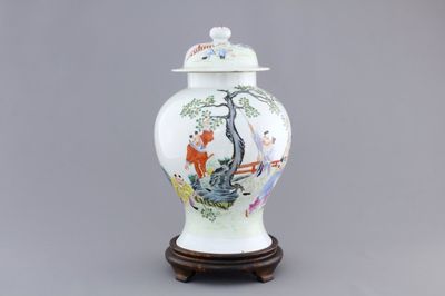 A Chinese famille rose porcelain vase with playing boys on a wooden stand, 19th C.