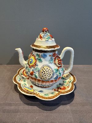 A Chinese famille rose teapot and stand with floral relief design, Qianlong — photo 1