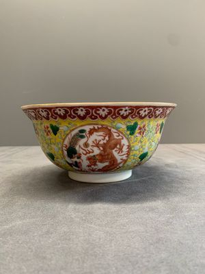 A Chinese famille rose yellow-ground 'dragon and phoenix' bowl, artemisia leaf mark, Guangxu — photo 1