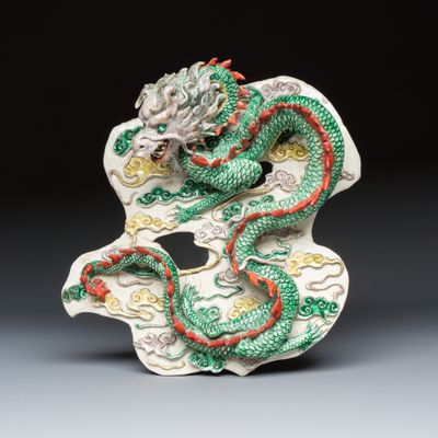 A Chinese famille verte biscuit 'Dragon among Clouds' wall plaque, 19/20th C.