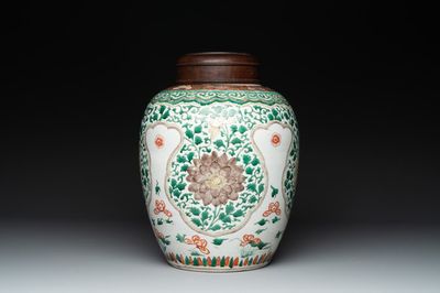A Chinese famille verte jar with floral design and a wooden cover, Kangxi