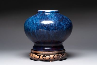 A Chinese flambé-glazed vase on a wooden stand, 19th C.