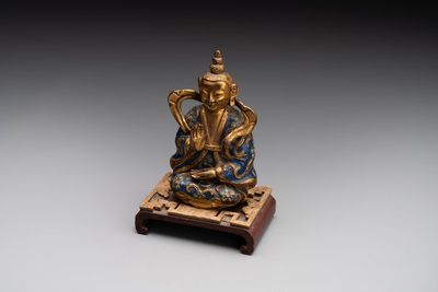 A Chinese gilt and champlevé enamelled bronze Bodhisattva on a carved stone stand, Qing