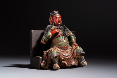 A Chinese gilt and polychrome lacquered papier-mâché and wooden Guandi on a wooden stand, 19th C.