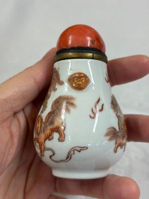 A Chinese gilt iron-red-decorated 'Buddhist Lions' snuff bottle with a red coral stopper — foto 2