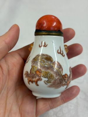 A Chinese gilt iron-red-decorated 'Buddhist Lions' snuff bottle with a red coral stopper — foto 3