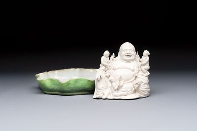 A Chinese green-enamelled lotus leaf-shaped brush washer and a Dehua blanc de Chine Milefo Buddha, 19th C