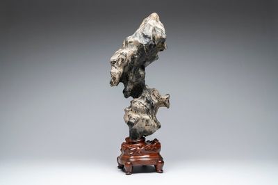 A Chinese green Lingbi stone scholar's rock on wooden stand, 20th C.