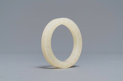 A Chinese inscribed white jade ring, 19/20th C.