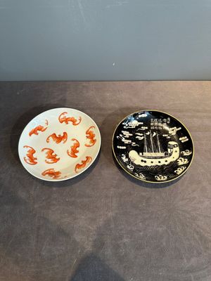 A Chinese iron-red 'bat' saucer and a black-glazed 'ship' saucer with calligraphy, Guangxu mark, 19th C. — photo 1