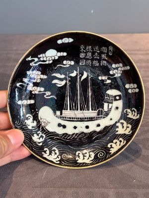 A Chinese iron-red 'bat' saucer and a black-glazed 'ship' saucer with calligraphy, Guangxu mark, 19th C. — photo 11