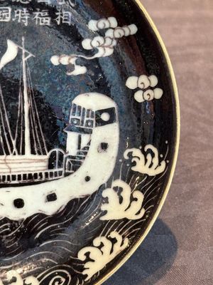 A Chinese iron-red 'bat' saucer and a black-glazed 'ship' saucer with calligraphy, Guangxu mark, 19th C. — photo 13