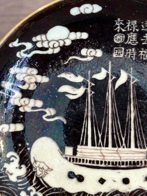 A Chinese iron-red 'bat' saucer and a black-glazed 'ship' saucer with calligraphy, Guangxu mark, 19th C. — photo 16