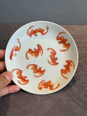 A Chinese iron-red 'bat' saucer and a black-glazed 'ship' saucer with calligraphy, Guangxu mark, 19th C. — photo 2