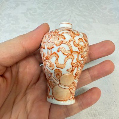 A Chinese iron-red-decorated relief-moulded 'An Ba Xian 暗八仙' snuff bottle — photo 1
