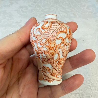 A Chinese iron-red-decorated relief-moulded 'An Ba Xian 暗八仙' snuff bottle — photo 2