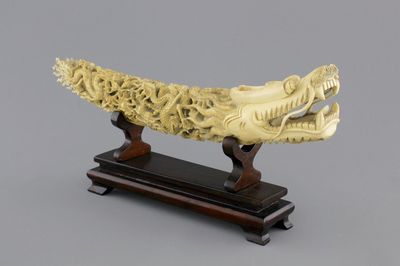 A Chinese ivory carving of a dragon on wooden stand, early 20th C.