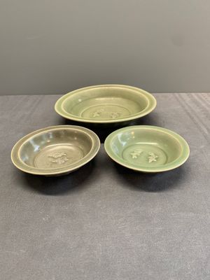 A Chinese Longquan celadon 'twin fish' dish and two 'twin fish' saucers, Yuan/Ming — photo 1