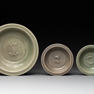 A Chinese Longquan celadon 'twin fish' dish and two 'twin fish' saucers, Yuan/Ming — photo 1