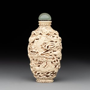 A Chinese moulded cream-glazed 'dragon and phoenix' snuff bottle, Jiaqing mark, 19th C. — foto 1