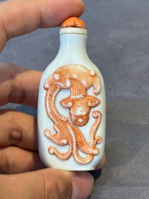 A Chinese moulded iron-red 'chilong' snuff bottle, 19th C. — photo 1