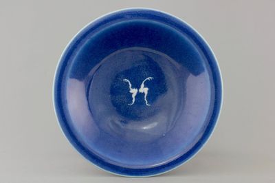 A Chinese porcelain monochrome blue ground plate with two bats, 19th C.