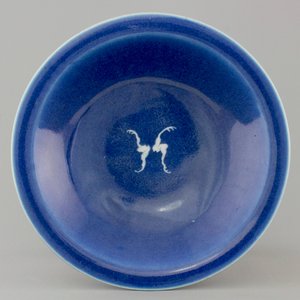 A Chinese porcelain monochrome blue ground plate with two bats, 19th C. — photo 1