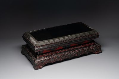 A Chinese rectangular carved red and black lacquer stand, 20th C.