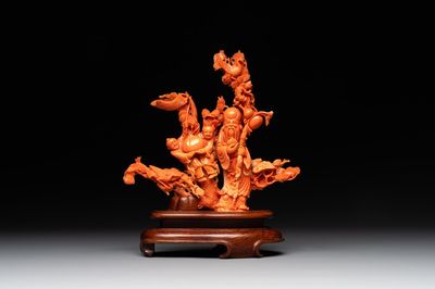 A Chinese red coral group of Shoulao with two boys holding a peach, inscribed 'Shou Bi Nan Shan 壽比南山', 19/20th C.