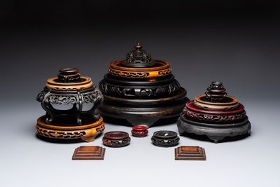 A Chinese reticulated wooden cover and 17 wooden stands, 19/20th C.