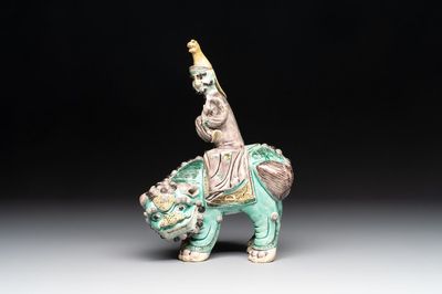 A Chinese verte biscuit 'Sogdian riding a Buddhist lion' group, 19th C.