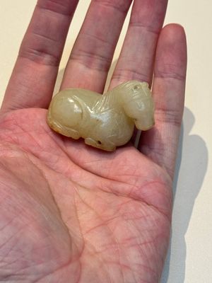 A Chinese white and russet jade pendant in the form of a horse, Song/Ming — photo 1