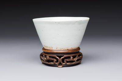 A Chinese white-glazed cup on a wooden stand, 17th C.