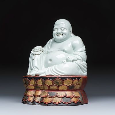 A Chinese white-glazed Milefo Buddha on a gilt-lacquered wooden lotus throne, Republic